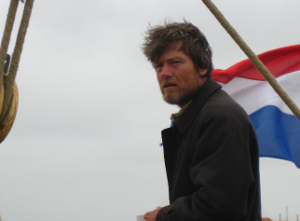 De schipper van de Zwarte Ruiter aan het roer. Hier
                zeilen op de Eems vlakbij Emden